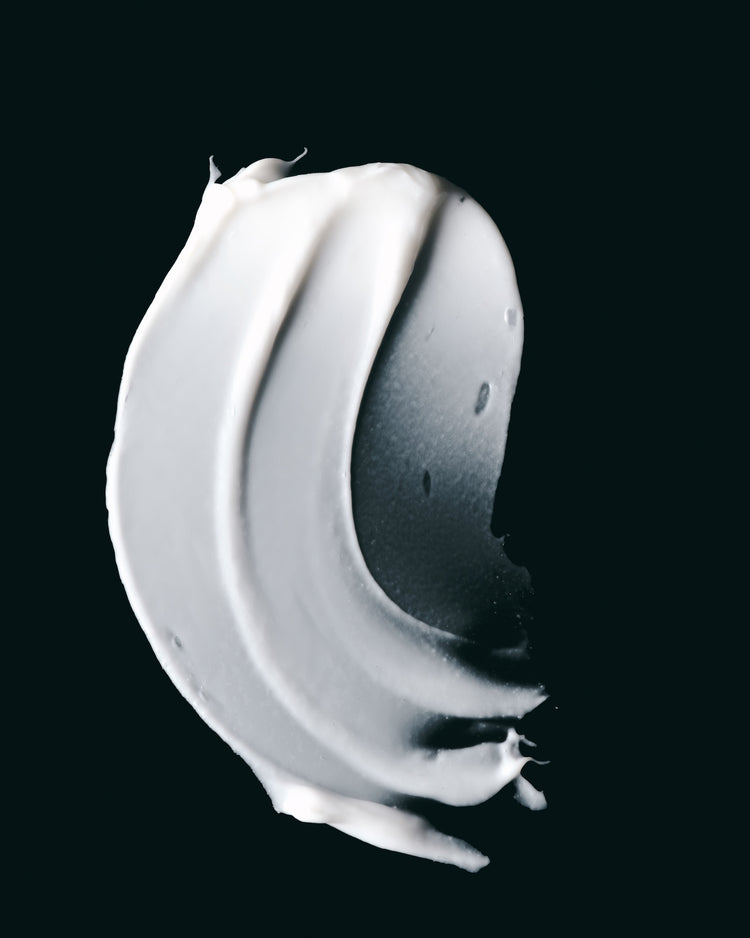 Le Conditioner hydrating texture smeared on a dark surface.