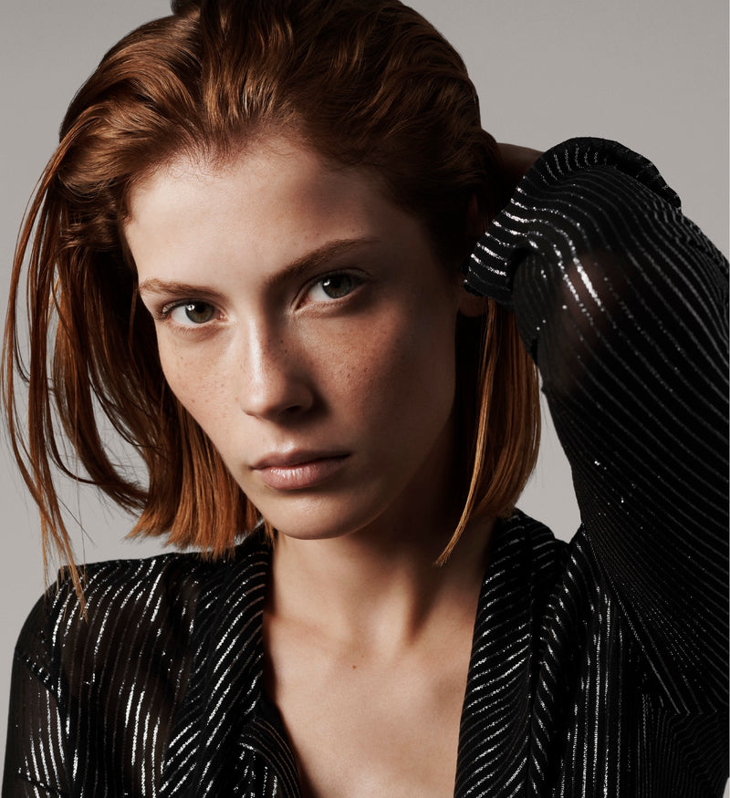 Close up of sleek, styled copper-colored bob with hair smoothed back in a polished finish to highlight shine.