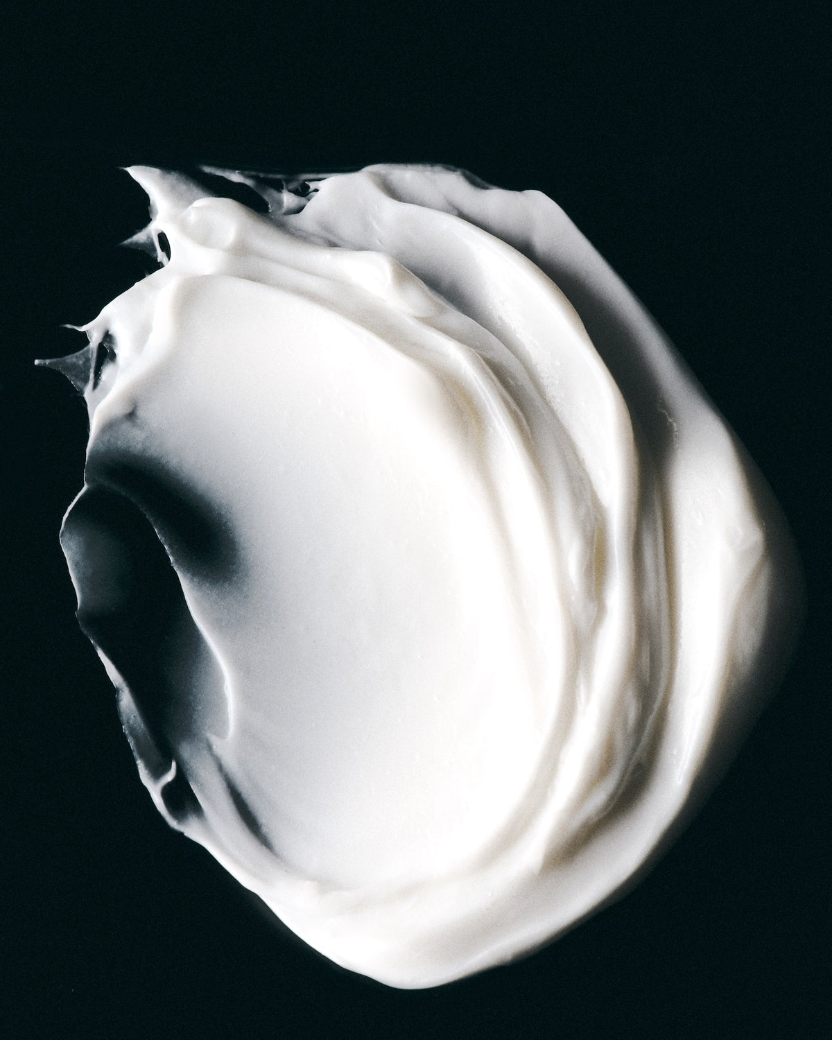 Le Ultimate Mask damage repairing and hydrating texture spread on black surface.