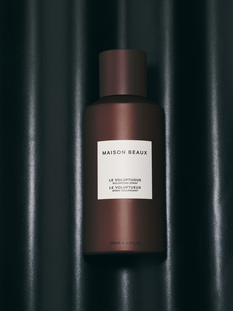 Le Voluptuous 250 ML spray bottle on a dark backdrop.