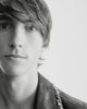Black & white close-up video of a model with short, side-swept hair