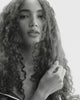 Black & white close-up of a model with soft, defined curls