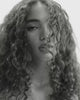 Black & white close-up of a model with soft, defined curls